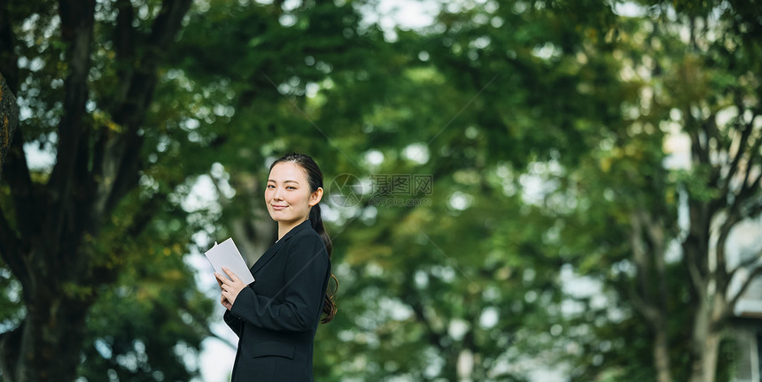 拿着书微笑的职业女性图片