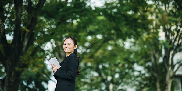 拿着书微笑的职业女性图片