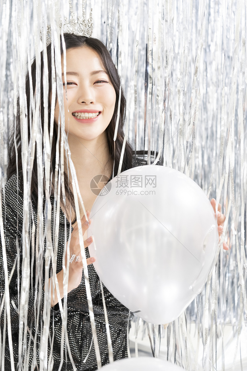 派对上拿着气球开心的年轻女子图片