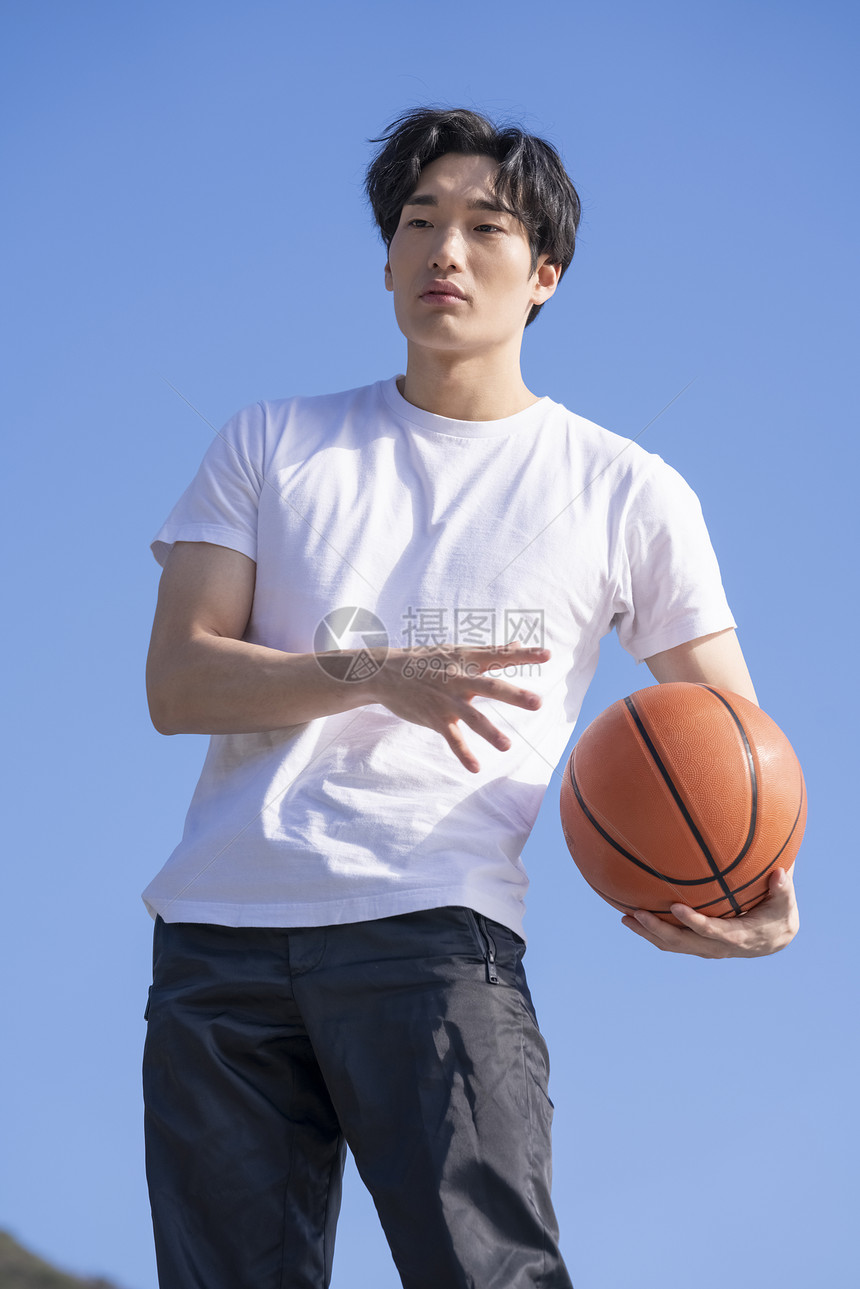 白体恤男青年拿着篮球图片