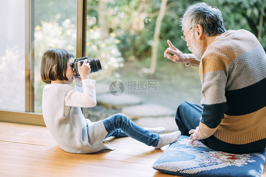 孙女用相机给爷爷拍照图片