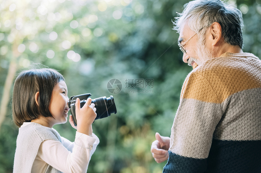 孙女用相机给爷爷拍照图片