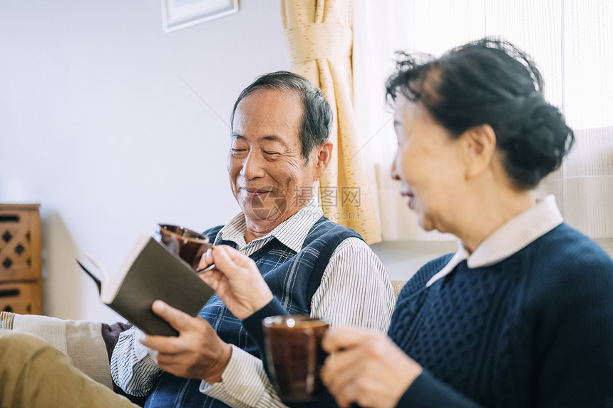 沙发上年长的夫妇喝下午茶图片