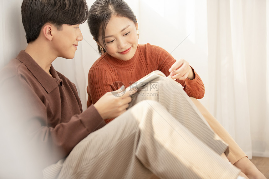 房间里阅读的年轻情侣图片