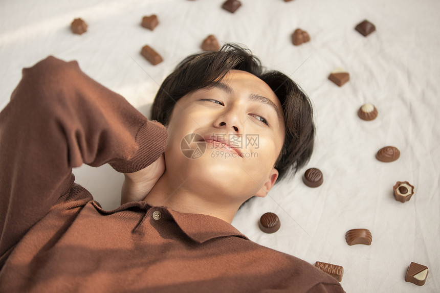 躺在巧克力堆里的青年男子图片