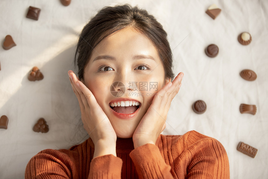 假日日光女生躺着用巧克力的年轻女子图片
