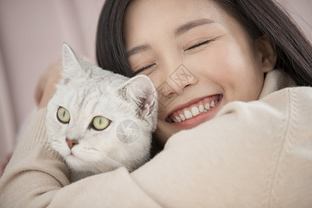 抱着宠物猫咪开心的年轻女子图片