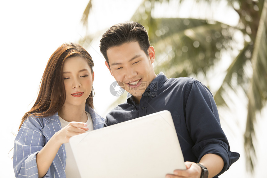 在户外的男人和女人看着电脑图片