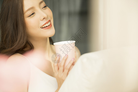 倚在沙发上喝咖啡的女生图片