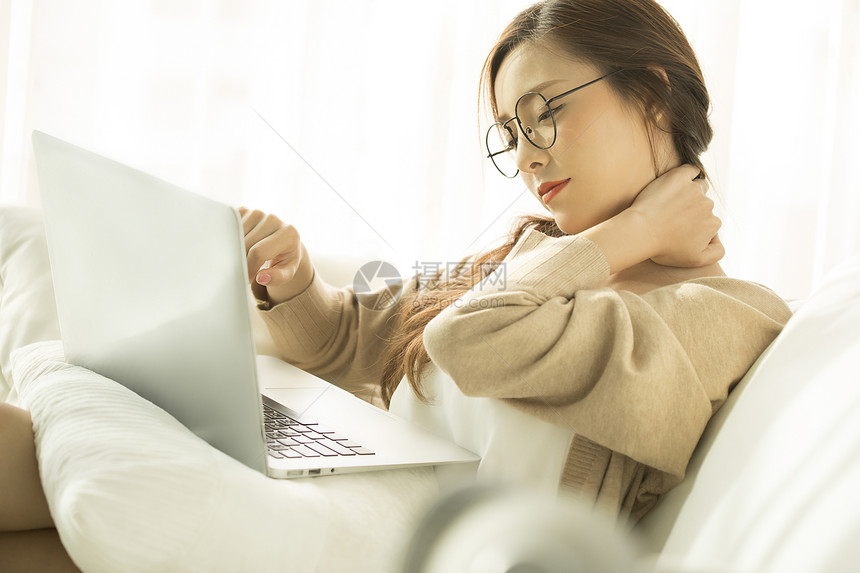 使用笔记本电脑疲惫的年轻女子图片