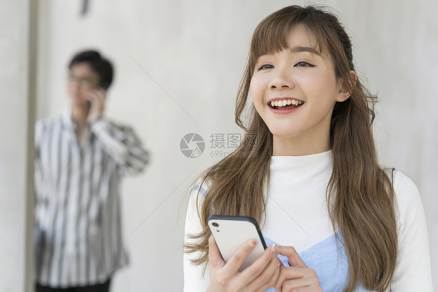 太阳光肖像快乐年轻的男人和女人在户外的智能手机图片