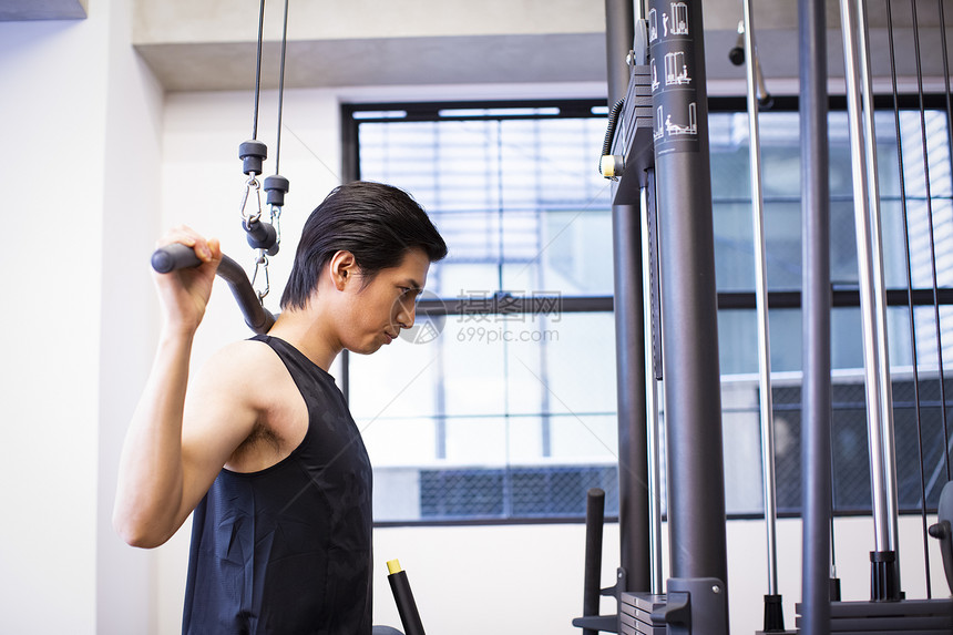 健身房使用器材健身的成年男子图片