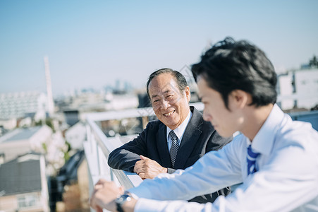 天台上聊天的商务人士高清图片