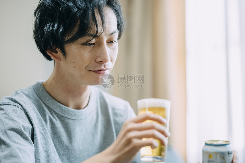 居家独自喝啤酒的成年男子图片