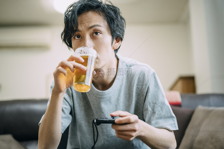 居家喝啤酒的成年男子图片
