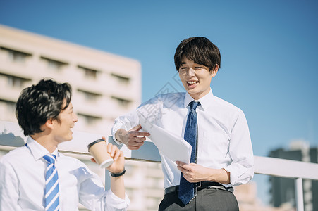 年轻商务男性站在天桥上交流高清图片