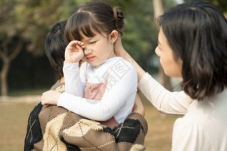 父母安慰哭泣的小女孩图片