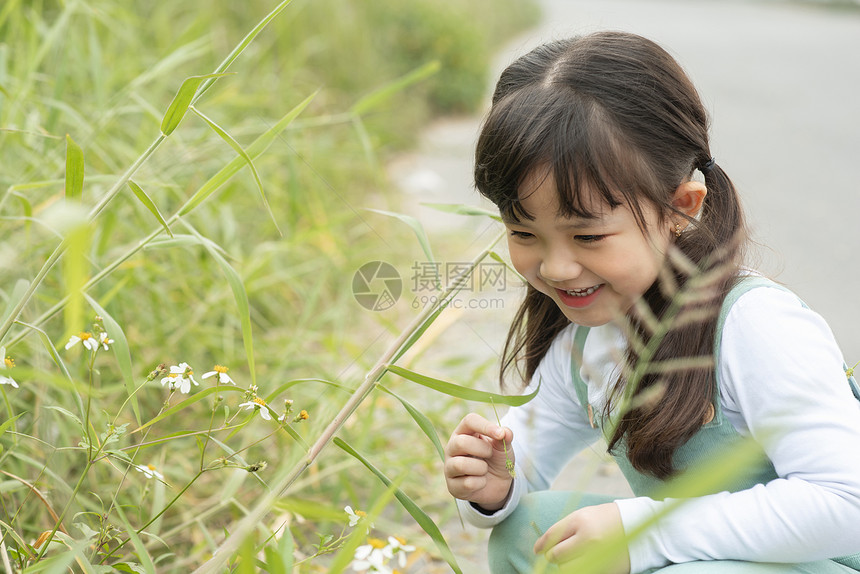 户外蹲在地上可爱的小女孩图片