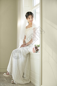 坐在窗边的美丽新娘图片