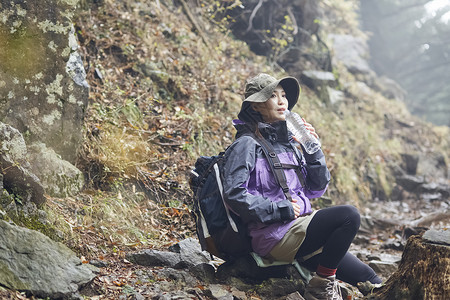 年轻女人徒步登山探险休息喝水图片