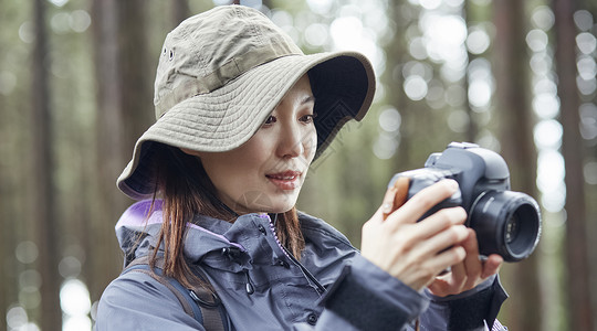 年轻女性户外徒步爬山休息拍照图片