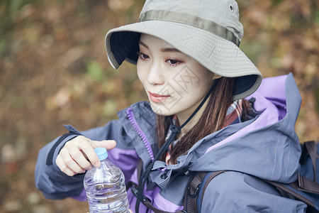 年轻女人徒步登山探险喝水图片