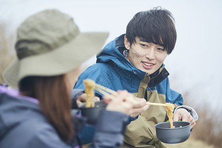 年轻情侣户外露营用餐图片