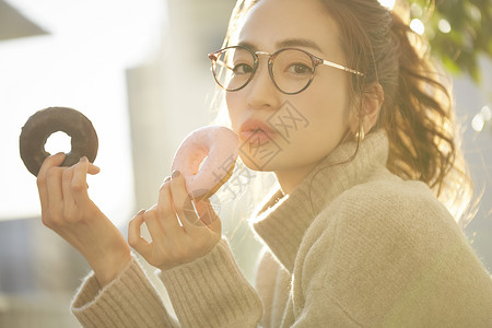 拿着甜甜圈的青年女子图片