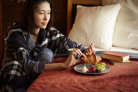 居家女性在卧室里吃早餐图片