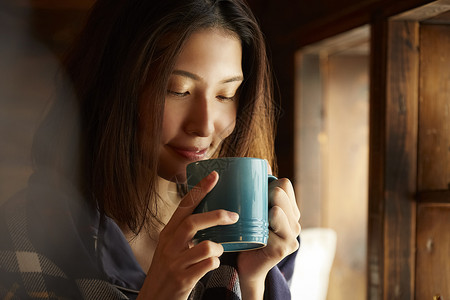 女用披肩青年女子低头喝咖啡背景