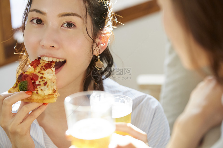 吃着披萨开心的年轻女子图片