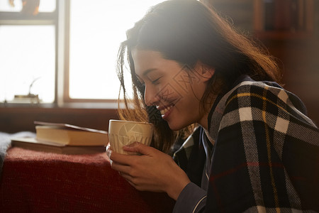 卧室里捧着咖啡的年轻女子图片