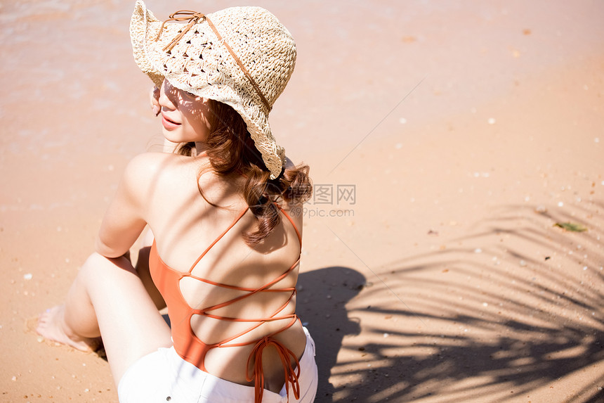 坐在海滩上的年轻女子图片