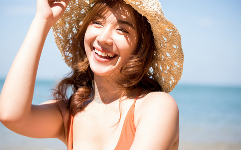 年轻女生高兴泳装的一名妇女坐在海滩图片