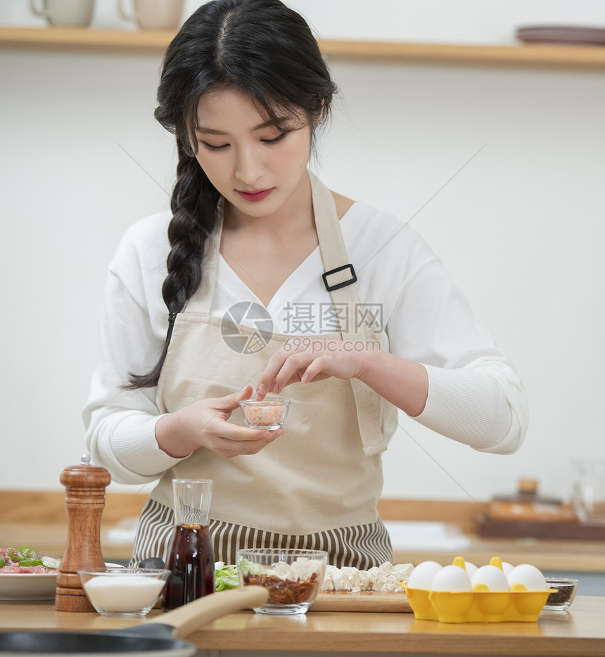 拍摄烹饪做菜短视频的年轻女子图片