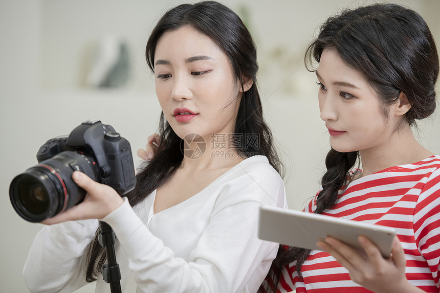 拍摄烹饪做菜短视频的年轻女子图片