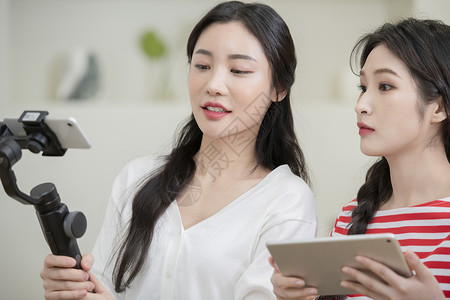 拍摄烹饪做菜短视频的年轻女子高清图片