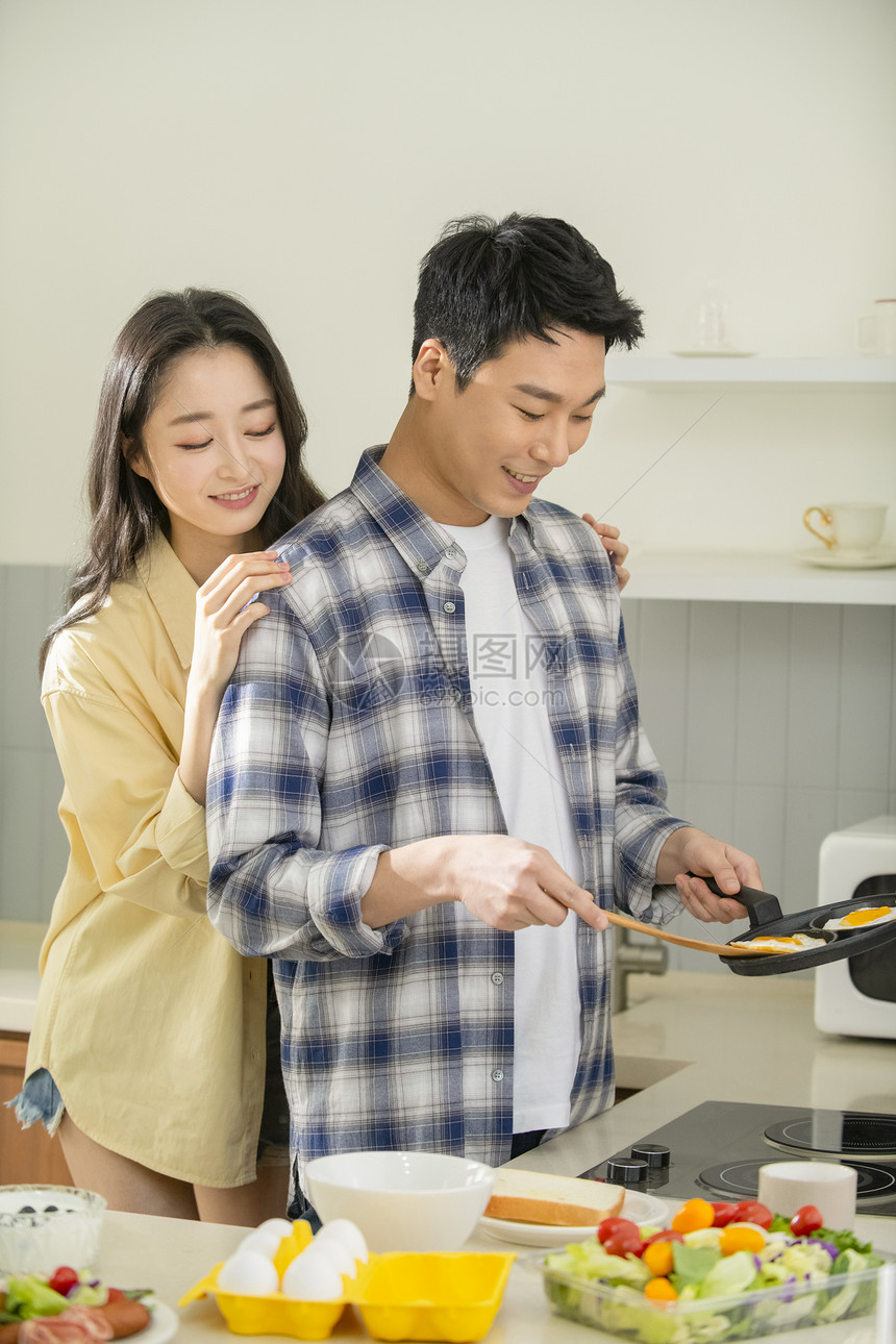 新婚夫妇居家烹饪早餐图片