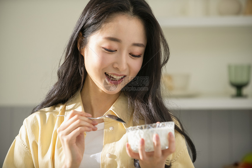 拿着酸奶碗微笑的年轻女子图片