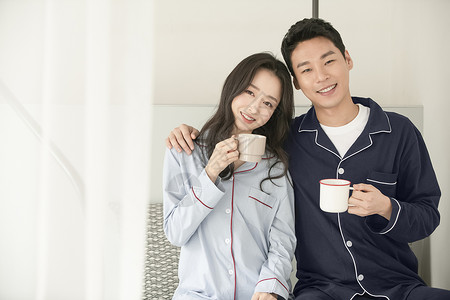 居家放松拿着咖啡的年轻夫妇背景图片