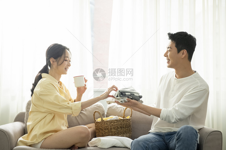 居家整理衣物的年轻夫妇图片