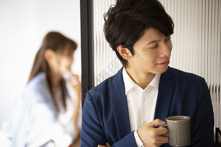 办公室里拿着杯子的男人图片