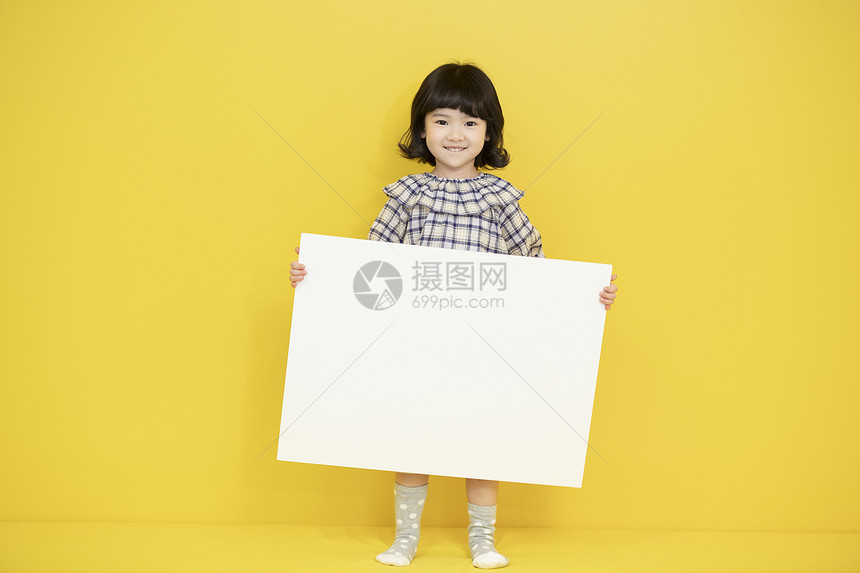 活泼可爱的幼儿园小女孩拿着画纸图片