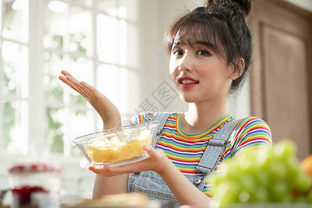 拿着一碗水果的青年女子图片