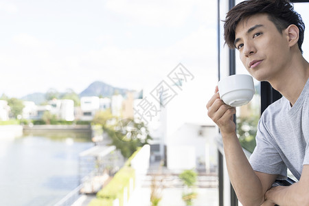 窗边喝咖啡的青年男性图片