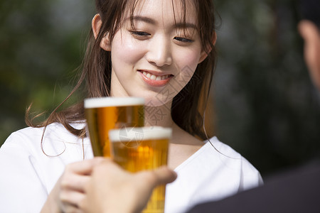 户外喝啤酒放松的年轻女子图片