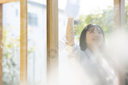 清洗窗户玻璃的年轻女子图片