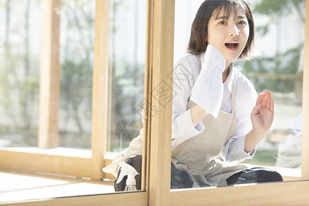 清洁窗户的年轻女子图片