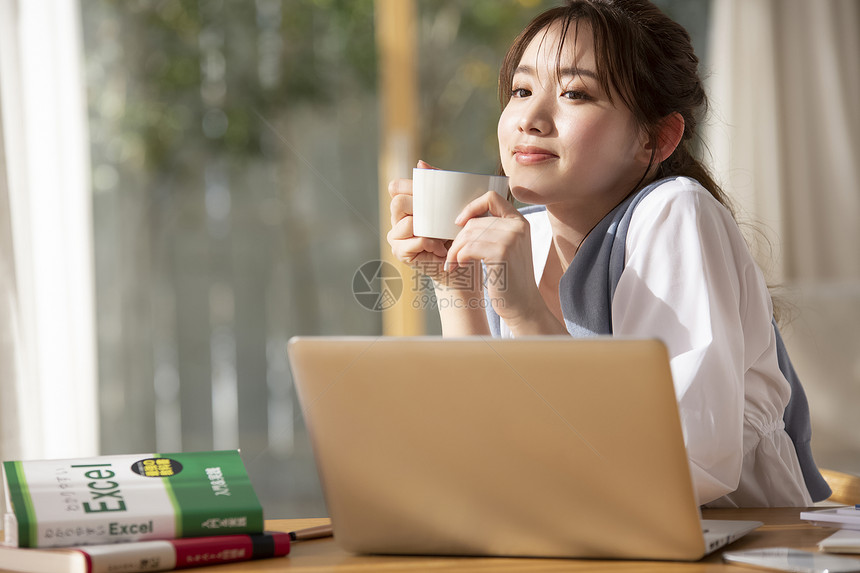 居家办公喝咖啡的年轻女子图片