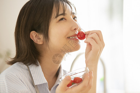 拿着蕃茄微笑的年轻女子图片